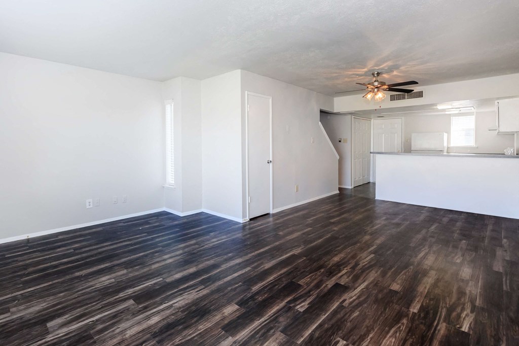a living room with a hard wood floor and a ceiling fan