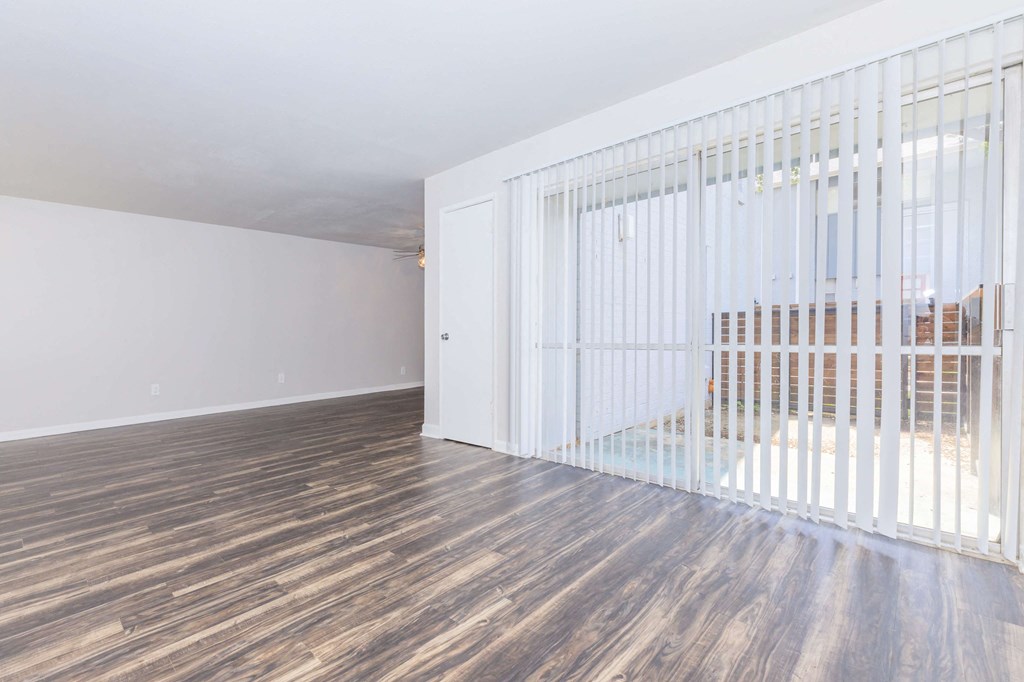 the living room of a house with wood floors and a white gate
