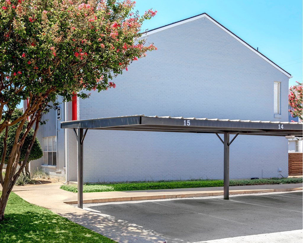 a covered parking lot in front of a building