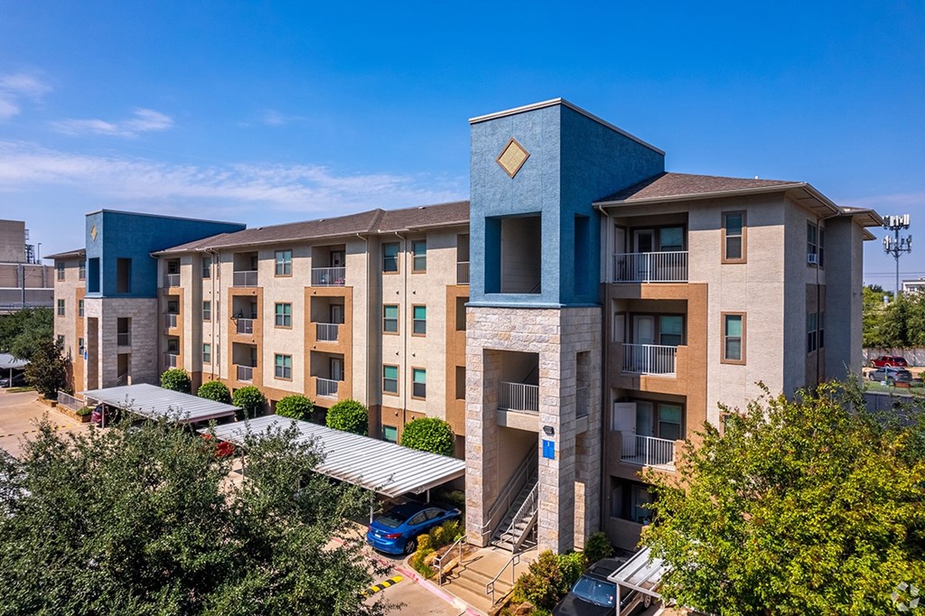 A modern apartment complex with a blue building in the foreground.