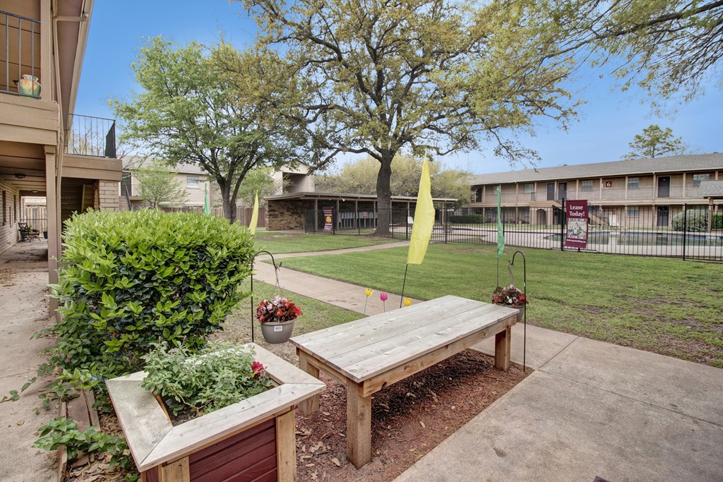A wooden bench sits in the middle of a garden.