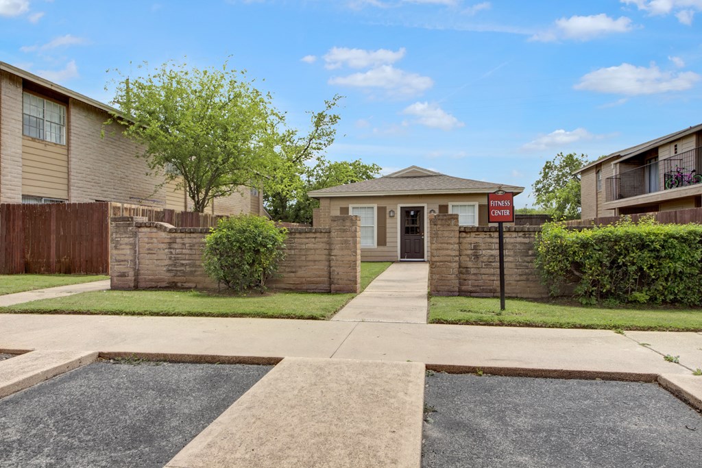 the view of an apartment building with a driveway and a street sign