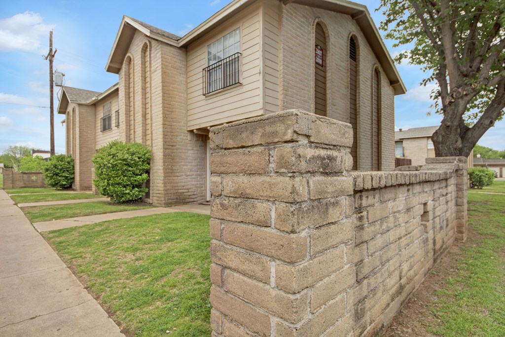 a stone retaining wall in front of a house