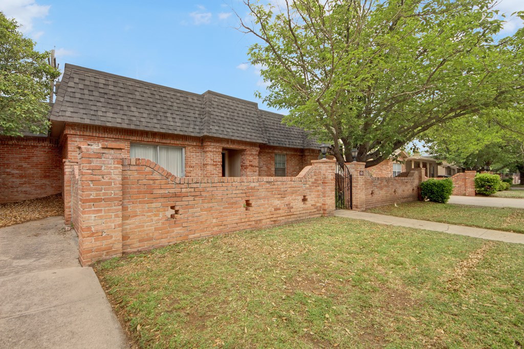 a brick house with a tree in front of it