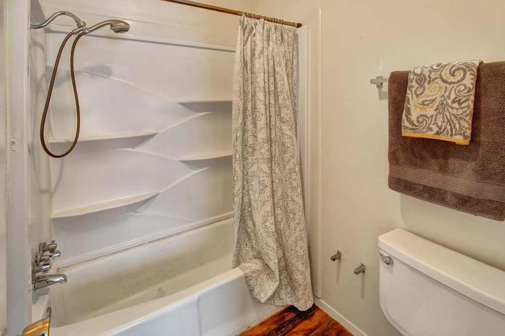 a bathroom with a shower and a toilet and a shower curtain
