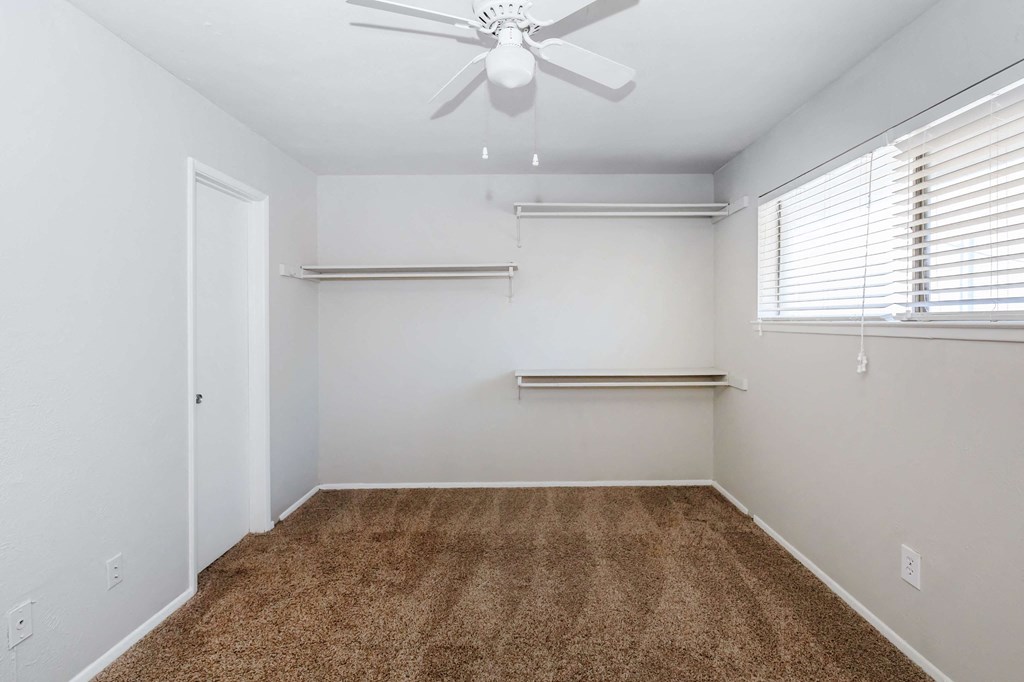 a room with a carpet and a ceiling fan