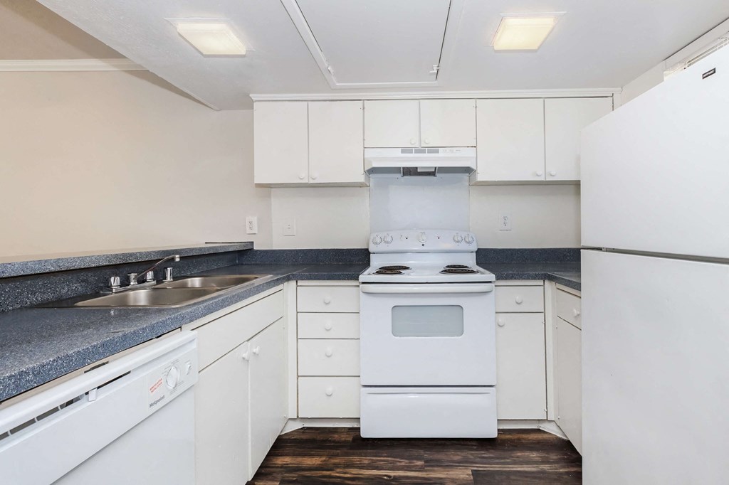 a kitchen with white cabinets and a stove and a sink