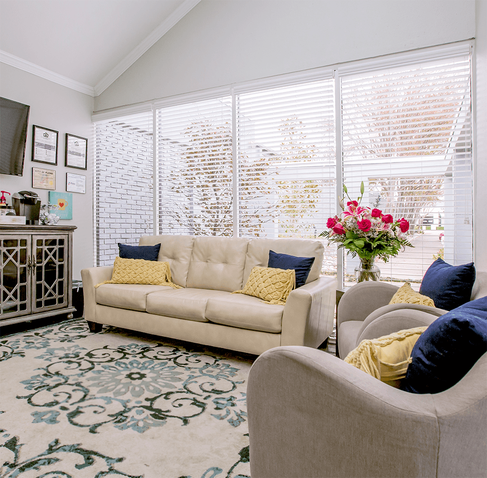 a living room with a couch and chairs and a large window