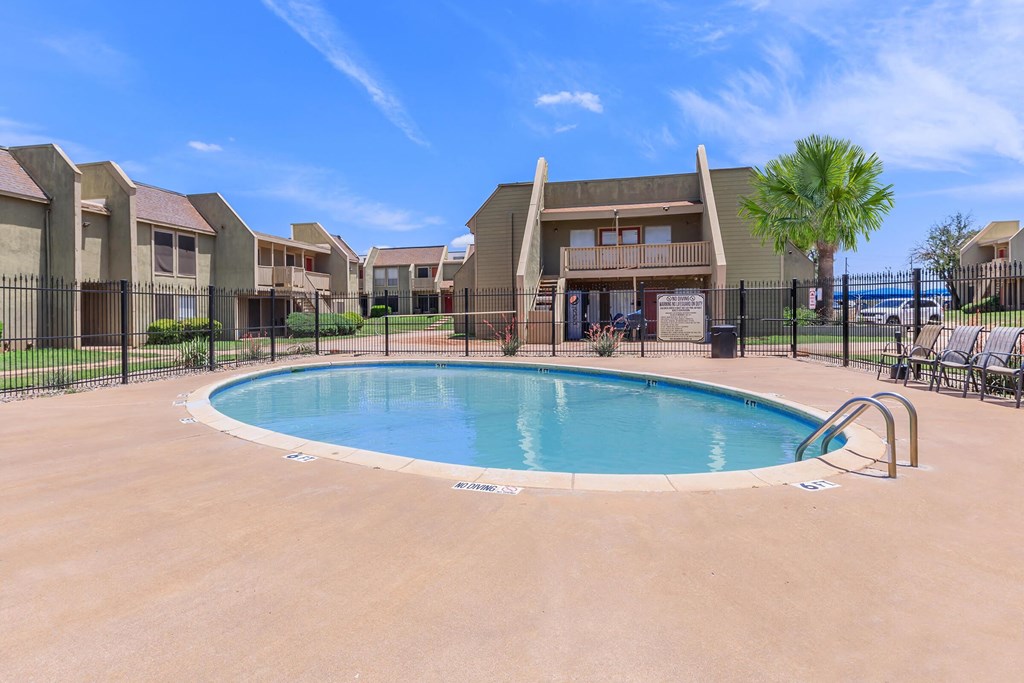 A swimming pool in a residential area with houses in the background.