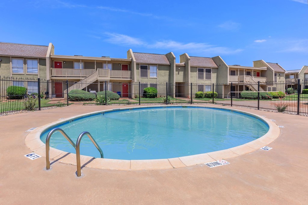a swimming pool with an apartment building in the background