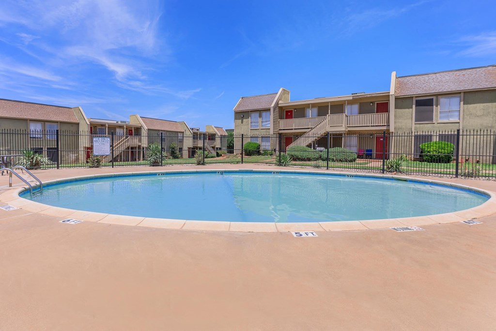 a swimming pool with an apartment building in the background