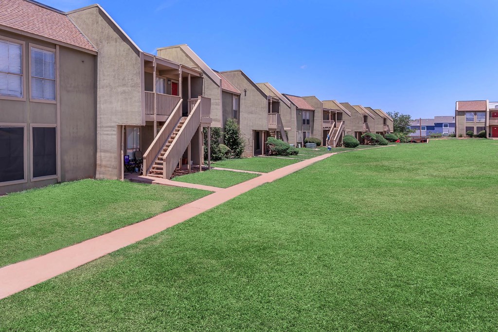 a row of houses with stairs and green grass