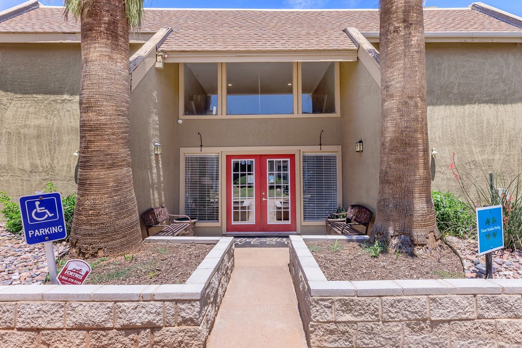 a house with a red door and two palm trees