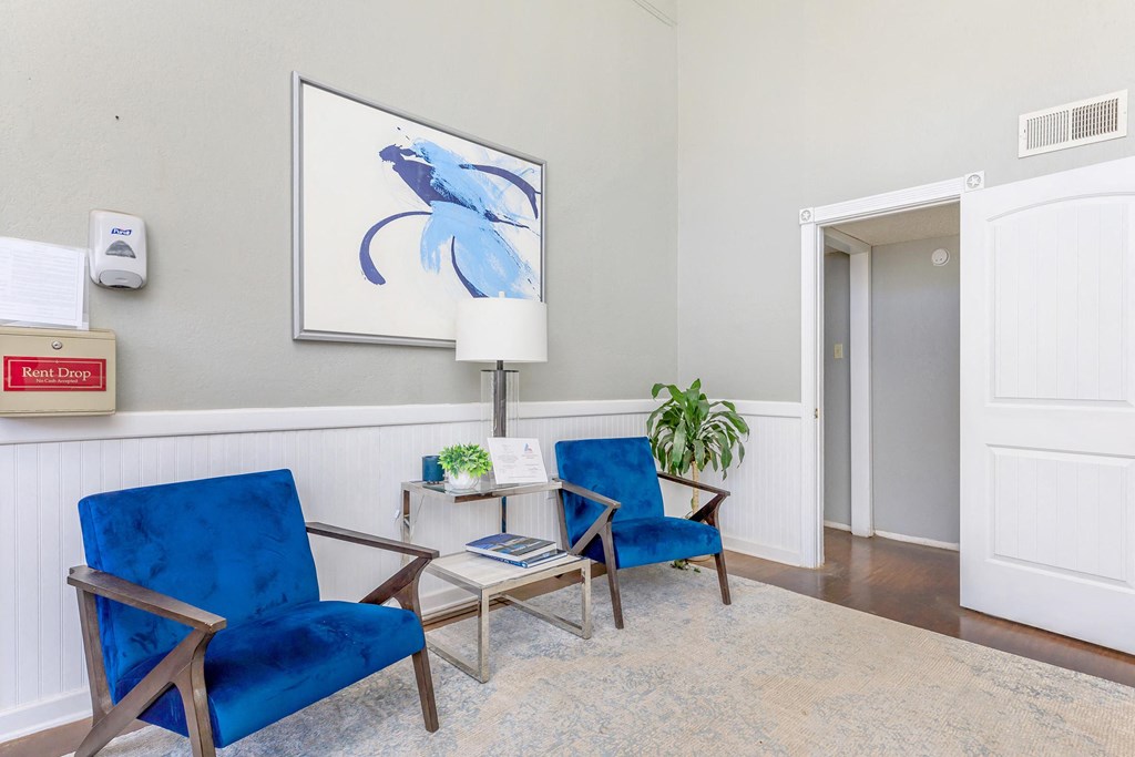 a living room with two blue chairs and a table