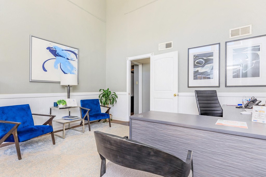 a room with a desk and chairs and a door