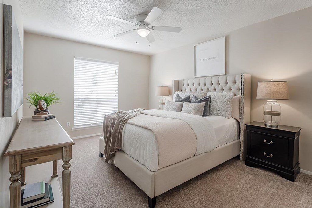 a bedroom with a bed and a ceiling fan