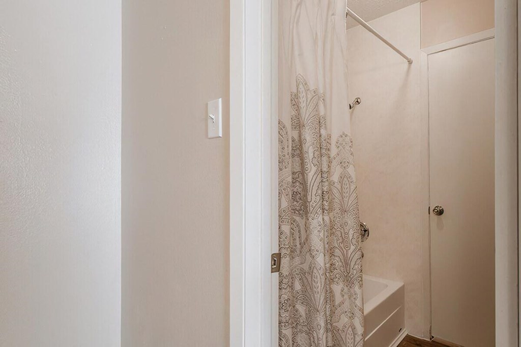 a small bathroom with a closet and a staircase