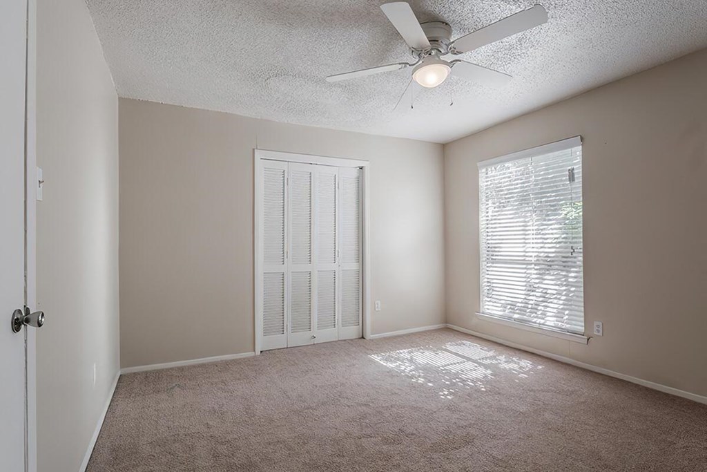 a bedroom with a ceiling fan and a window