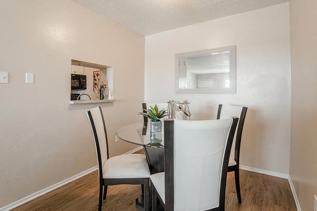 a dining room with a glass table and chairs
