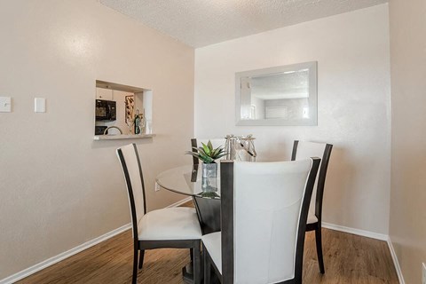 a dining room with a glass table and chairs