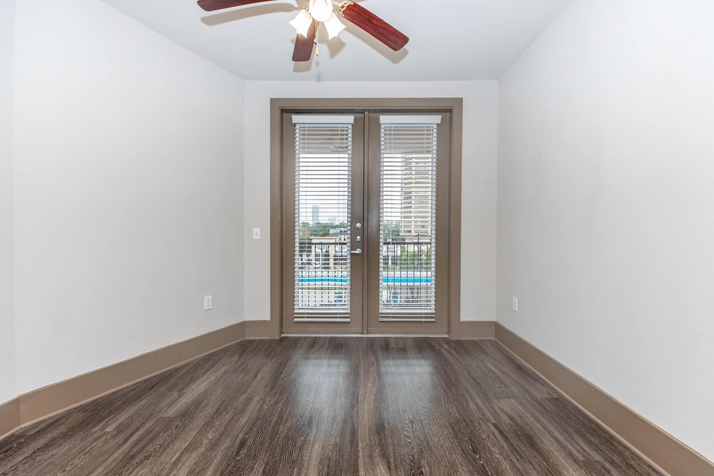 a living room with a door and a ceiling fan