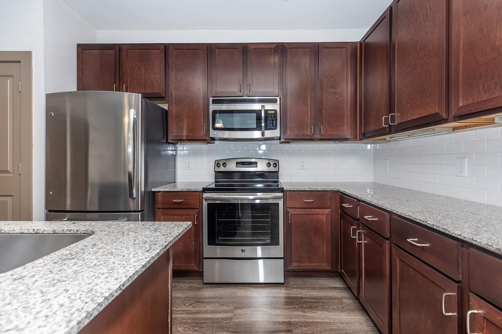 a kitchen with stainless steel appliances and marble counter tops
