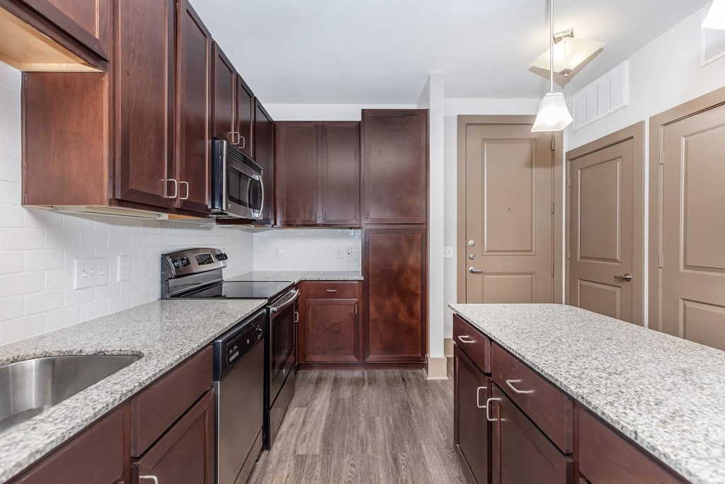 a kitchen with granite counter tops and wooden cabinets