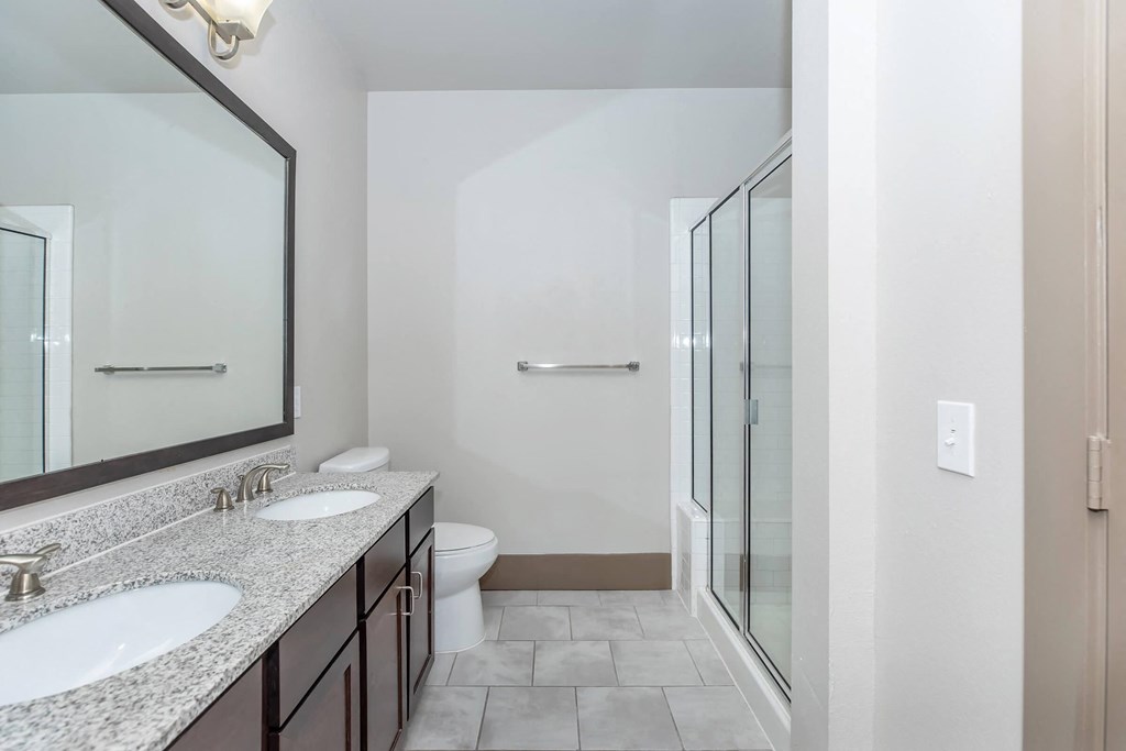 a bathroom with two sinks and a shower and a toilet