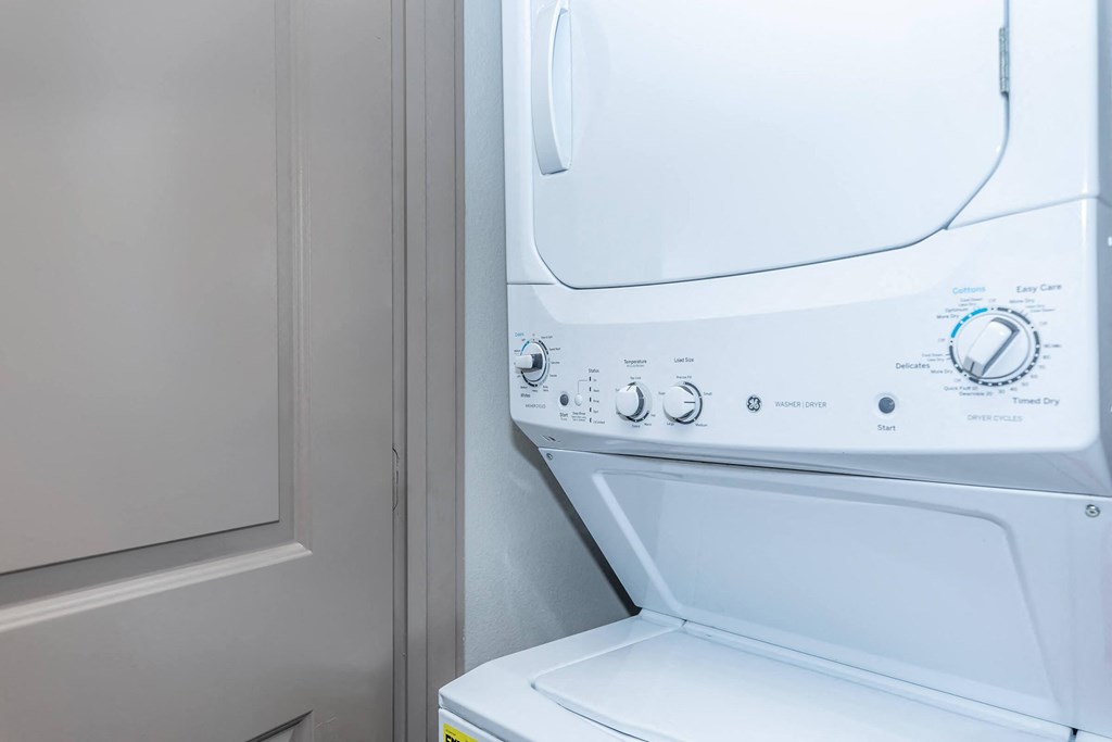 a washer and dryer in a laundry room with a white door