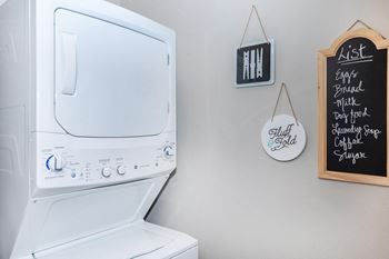 the laundry room has a large washer and dryer and a wall mounted tv