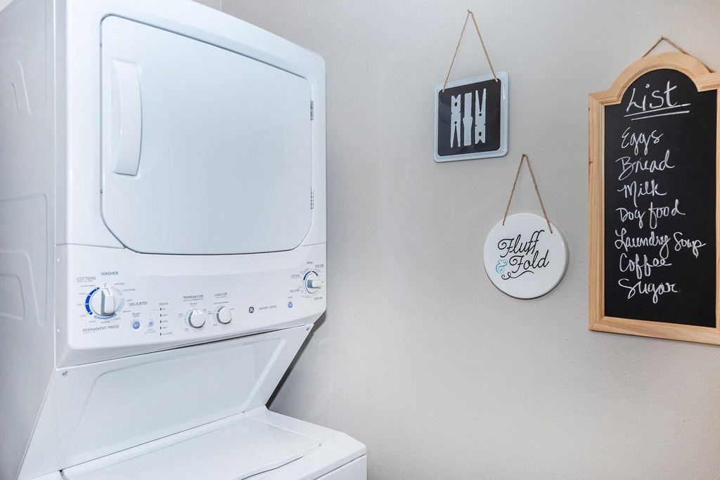 the laundry room has a large washer and dryer and a wall mounted tv