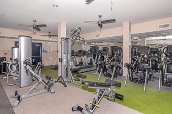 a gym with weights and cardio equipment in a building