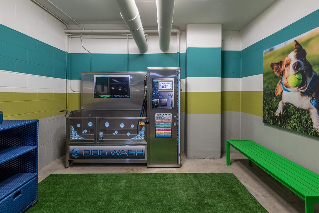 a dog wash room with a vending machine and a green bench
