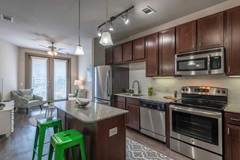 a kitchen with stainless steel appliances and green bar stools