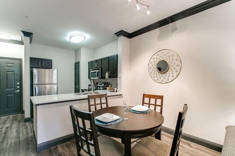 a dining room and kitchen with a table and chairs