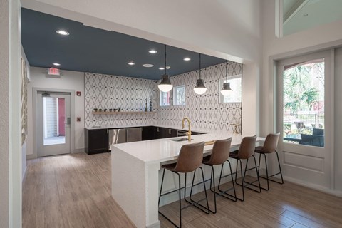 a kitchen with a white counter and chairs