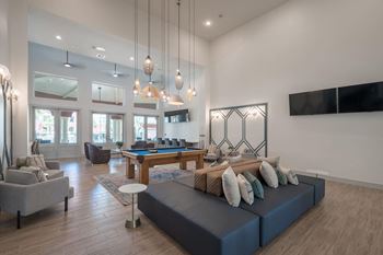 a living room with a blue couch and a pool table