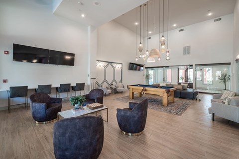 a living room with a pool table and chairs
