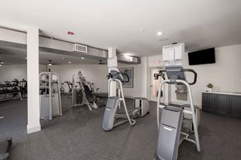 a gym with weights and cardio equipment in a building