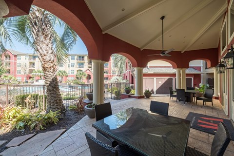 a patio with a table and chairs and a palm tree