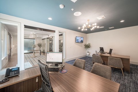 a conference room with a desktop computer on a wooden desk
