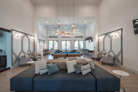a large living room with a pool table and couches