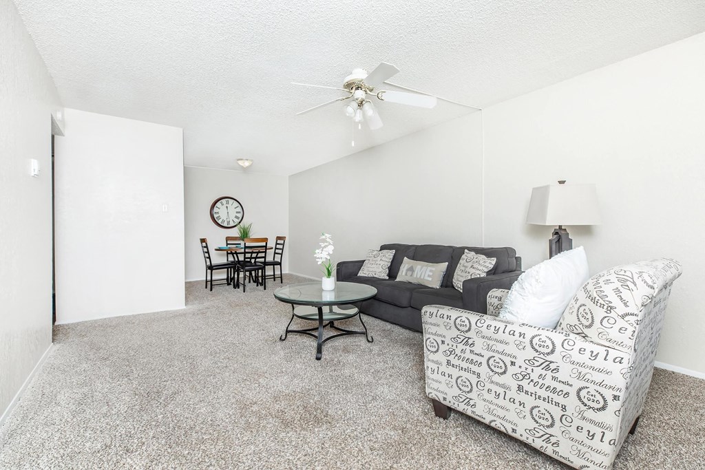 A living room with a grey couch and a black chair.