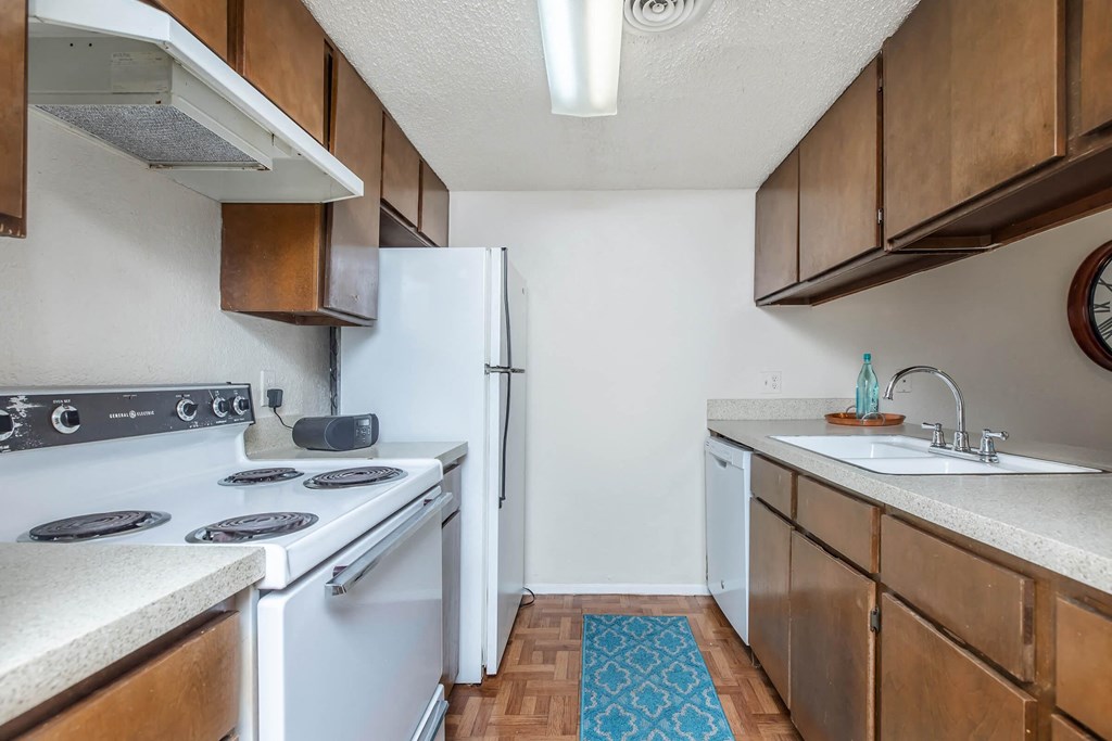 a kitchen with white appliances and wooden cabinets