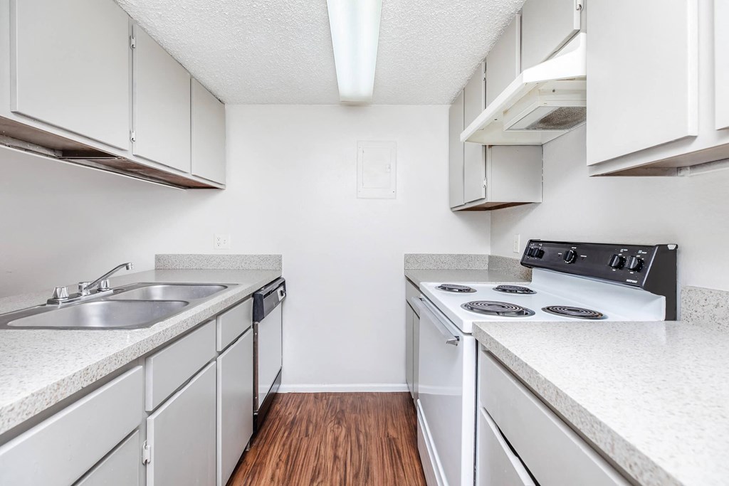 a kitchen with white cabinets and appliances and a sink