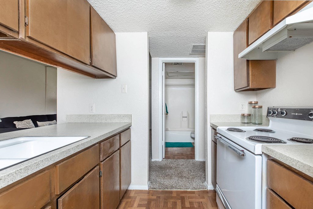 an empty kitchen with white appliances and wooden cabinets