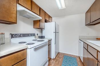 a kitchen with white appliances and wooden cabinets