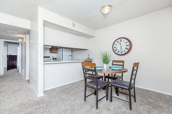 a dining room table with a large clock on the wall