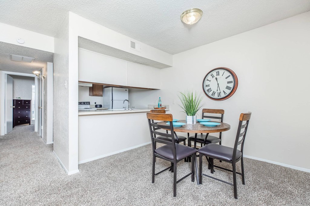 a dining room table with a large clock on the wall