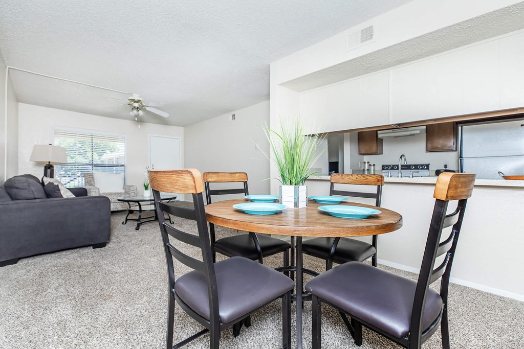 A dining room with a round table and chairs.
